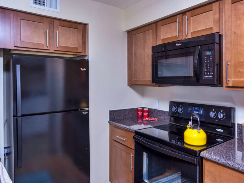 This image shows the updated kitchen area with faux granite countertops and Black Whirlpool Appliances.